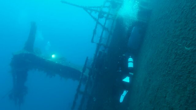 Scuba diver swims near shipwreck Swedish ferry MS Zenobia. Wreck diving. Mediterranean sea, Cyprus