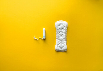Critical days. Woman hygienic protection, menstruation, cotton tampons, sanitary pads. Feminine hygiene panty liner for menstruation. Menstrual cycle, pad. Yellow colorful background. Top view, layout