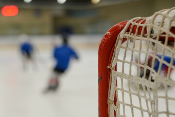 Children playing ice hockey in arena. Young hockey players practising.