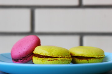 macaroons near a brick wall on a wooden table