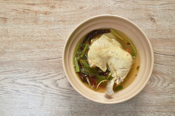 spicy chicken leg in tom yum soup on bowl
