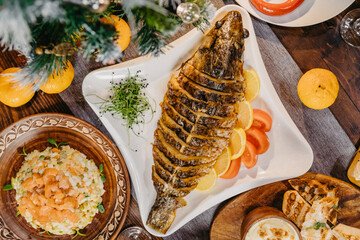 table on which there are traditional New Year's dishes prepared on the table in the Soviet Union: jellies with meat, olives, potatoes, baked chicken, grated horseradish, sausage, pate, vodka and champ