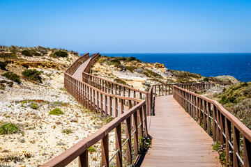 Fototapeta na wymiar Wooden walkways by the Atlantic Ocean in Zambujeira Do Mar, Alentejo, Portugal