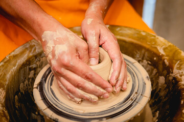 Potter working on potters wheel with clay. Process of making ceramic tableware in pottery workshop....