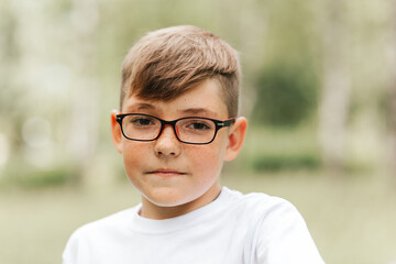 Portrait of a handsome boy with freckles and glasses