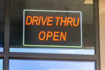 red sign reads drive thru open in restaurant window
