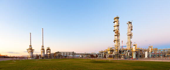 View of a gas refinery plant illuminated at dusk.