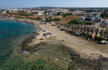 Fototapeta na wymiar Aerial drone view of Agia Triada coastline and people swimming in the sea. Protaras Paralimni Cyprus