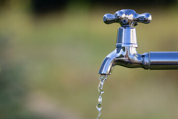 Metal tap with drain water outdoors