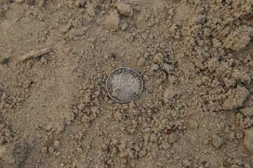 Fototapeta na wymiar Old silver coin on the ground