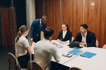 Businessman and businesswoman team mentor at office meeting. Business people different nationalities group conference discussion sit at table with boss man and woman