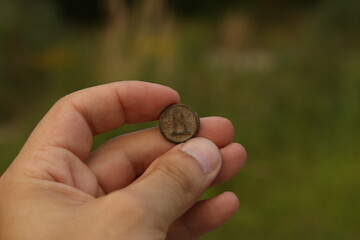 Ancient copper coin in hand