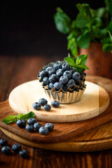 Juicy and fresh blueberries with green mint leaves on wooden table. Selective focus