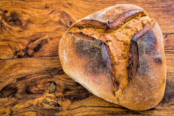ein dunkles brot auf einem holztisch