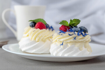 Pavlova dessert with raspberry, blueberry, and mint.