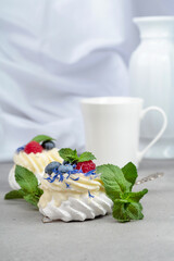 Pavlova dessert with raspberry, blueberry, and mint.