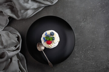 Pavlova dessert with raspberry, blueberry, and mint.