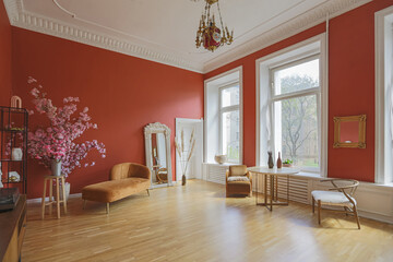 antique vintage interior in 19th century style living room with bright red walls, wood floor and direct sunlight inside the room.