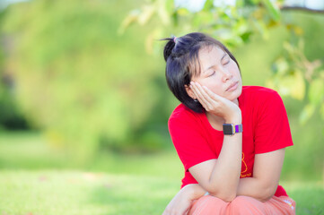 Calm beautiful smiling young woman with ponytail enjoying fresh air outdoor, relaxing with eyes closed, feeling alive, breathing, dreaming.