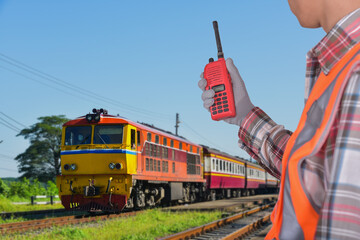 Engineer with Hand hold walkie talkie operate passenger train background