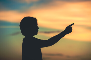 Fototapeta premium young woman pointing her hand aiming destination success at sunset.