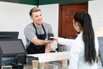 Fototapeta premium male barista giving a cup of coffee to customer in cafe or coffee shop