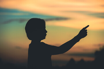 Fototapeta premium young woman pointing her hand aiming destination success at sunset.