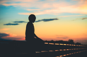 Fototapeta premium silhouette woman with sadness at sunset alone.
