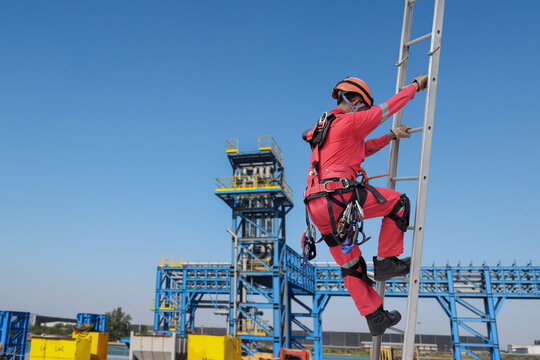 Technician wear seat belts safety harness go up the stairs fixed ladder working on the high ground in industrial plants prevent fall from a height wear protective equipment with space to enter text.