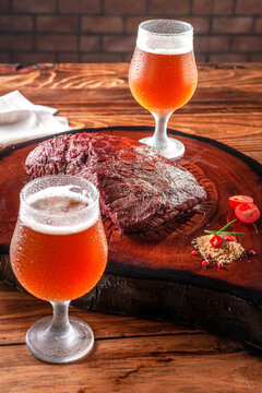 Grilled Denver Steak On Wooden Cutting Board With Two Sweaty Cold Tulipa Glasses Of Ale Draft Beer. Marble Meat Beef.