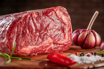 Raw entrecote beef on a wood cutting board with spices - Closeup.