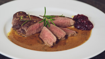 ready to eat, the roasted topside from a young roe deer in wine mustard sauce and cranberry jam
