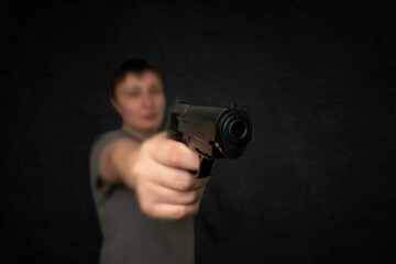 Fototapeta na wymiar Gun in the hand of the criminal person, selective focus on gun