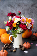 Obraz na płótnie Canvas Autumn pumpkins and flowers on dark background, fall warm and cozy composition
