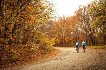 Fototapeta premium People riding bikes down a rural road