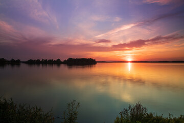Obraz na płótnie Canvas Lake Musov - South Moravia - Czech Republic. Calm water at sunset. Beautiful clouds in the sky.