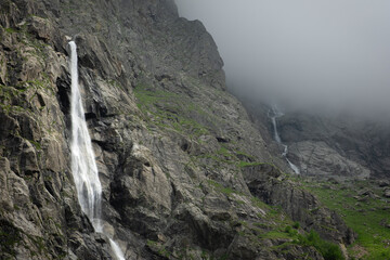 Obraz premium Panoramic landscape Midagrabin waterfalls in sunlight in cloudy summer weather. Caucasus mountains. Russia. North Ossetia Alania