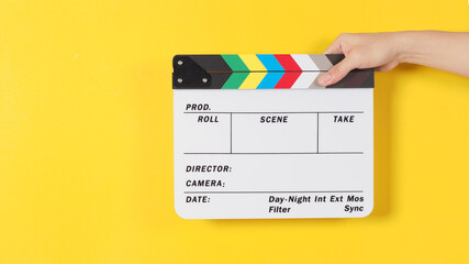 Hand is holding clapper board or movie slate or film slate.It is used in video production and...
