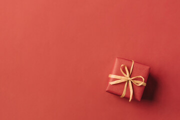 Gift boxe with brown bow on a red backdrop.