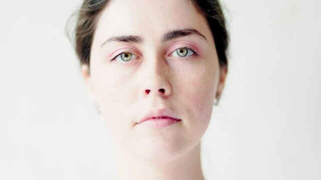Close-up portrait of a young Caucasian sad woman on a white background. The concept of beauty and psychology.