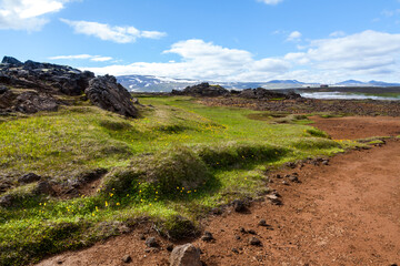 Summer Iceland volcano landscape with mountains, rocks, orange clay path.