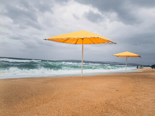 Yellow beach umbrellas on the sand. Storm.