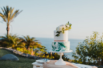 Wedding cake on table near sea