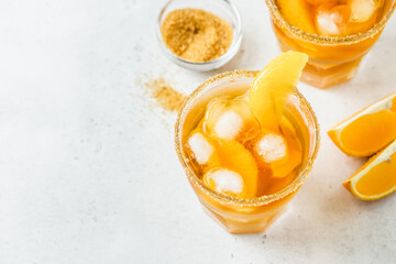 Refreshing orange cinnamon  iced tea, cool summer drink in glasses. Space for text.