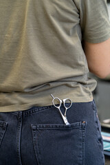 professional hairdressing scissors are in the back pocket of your jeans. High quality photo