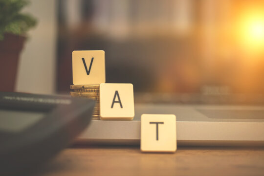 VAT word, calculating the taxes in Europe union with calculator and laptop on business desktop, management concept background photo