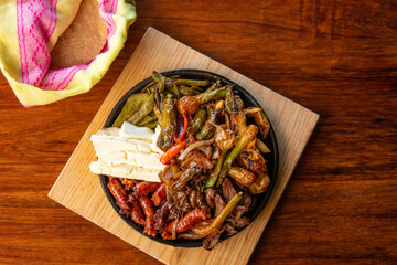 Authentic Mexican barbecue, different cuts roasted on a restaurant table. Chistorra, meat and grilled cheeses. Mexican roast beef concept.