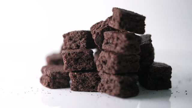 Extreme close up shot of stack homemade chocolate brownies with focused change, Pieces of fresh brownie on white background. Delicious chocolate pie.