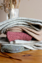 Pile of woolen knitted socks on wooden table