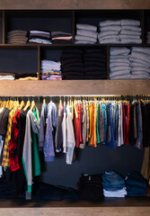 Men clothing shop, casual clothes on hangers and shelves in garments store